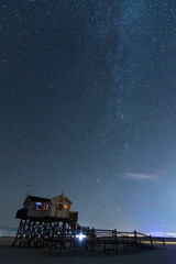 Pfahlbau mit Milchstraße und Sterne bei Nacht an der Nordsee