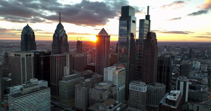 Philadelphia urban city skyline with silhouette of highrise skyscrapers at sunset. Dramatic sky in aerial sunrise.