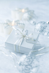 Christmas ornaments, candles and small present in white