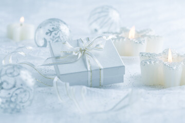 Christmas ornaments, candles and small present in white