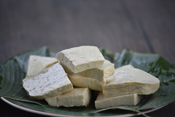 Tofu, also known as bean curd or Tahu in Indonesia language, is a food prepared by coagulating soy milk fermentation and then pressing the resulting curds into solid white blocks of varying softness 