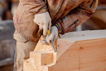 Industrial carpenter working with log, construction frame building site of house made of wood