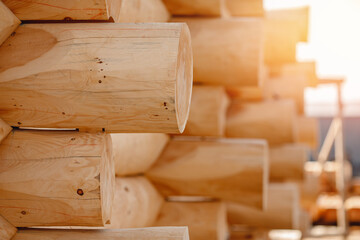 Close-up corner of wooden russian blockhouse, docking of round logs with sun light