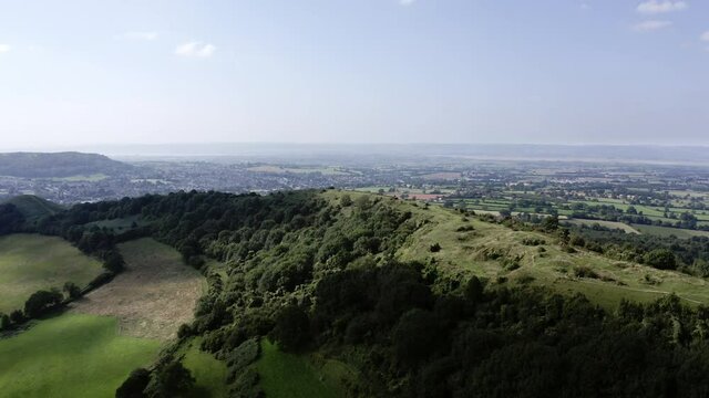 AERIAL - Beautiful hills and a blue sky near Uley, Cotswolds, England, reverse shot