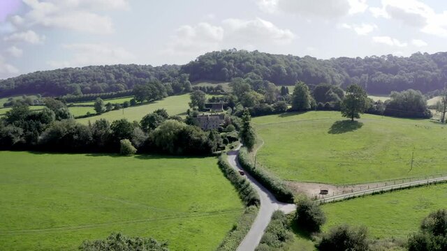 AERIAL - Country road and hills near Uley, Cotswolds, England, forward shot