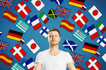 Portrait of attractive young european meditating man with abstract colorful flag drawings. Travel,...