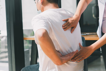 Obraz premium Doctor or physical therapist examines back pain and spinal area to give advice within the rehabilitation center.