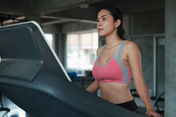 Portrait asia woman working out or exercise bike and wearing sportswear in fitness or gym center, Strength sporty female and weight loss concept