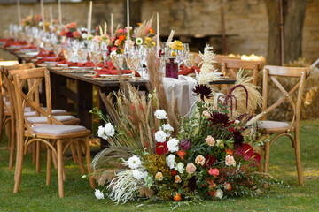A very nicely decorated wedding table appointments with beautiful decor with plates and serviettes in spring garden. Beautiful flowers on table in wedding day. The elegant dinner table.