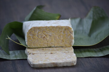 Tempeh or tempe is a traditional Javanese food made from fermented soybeans and made by a natural culturing and controlled fermentation process that binds soybeans into a cake form with a fungus