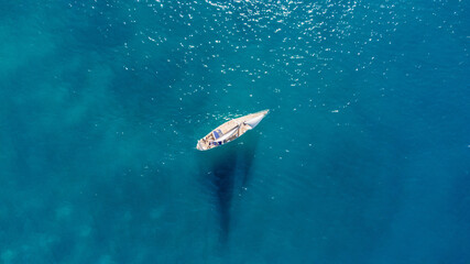 Fototapeta premium Drone aerial view of a sailing boat on a blue ocean sea waters.