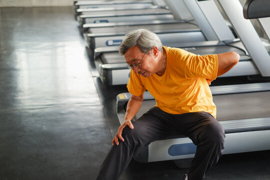 Portrait asia senior man have a backache after running treadmill in fitness gym