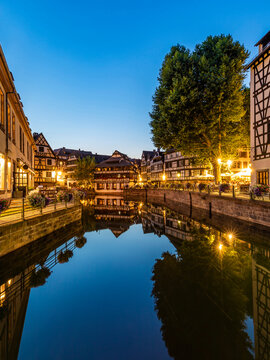 France, Bas-Rhin, Strasbourg, Long exposure of half-timbered houses reflecting in Petite FranceIll river canal at dusk