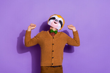 Photo of young sleepy man just waking up stretch arms incognito isolated over violet color background