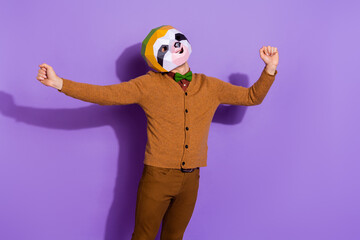 Photo of young sleepy man just waking up stretch arms incognito red panda isolated over violet color background © deagreez