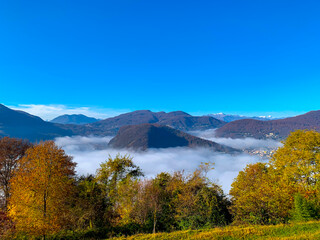 Mountain Range on the Border to Italy on Lake Lugano with Cloudscape and Sunlight on a Clear Sky in...
