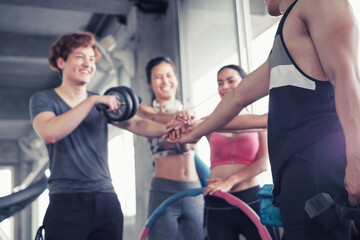 Fototapeta na wymiar Smiling group of asia friends, happy young women and men relax together after a workout at gym center, Strength sporty and weight loss concept