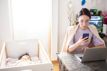 子供を寝かしつけて仕事をする母親