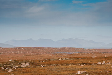 Huge fields and mountains in the background. Blue cloudy sky. Landscape scene in Connemara, county Galway, Ireland. Nobody. Warm and cool tone. Stunning nature in popular tourist region