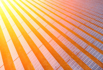 Aerial top view of a solar panels power plant. Photovoltaic solar panels at sunrise and sunset in countryside from above. Modern technology, climate care, earth saving, renewable energy concept. © panophotograph