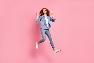 Full length photo of cheerful cute young woman jump up smile make v-signs isolated on pink color background
