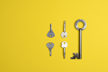Key on a yellow background, top view. Trendy colorful photo. Trendy minimal flat lay concept.