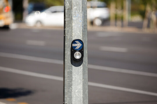 Pedestrian crossing traffic button with an arrow