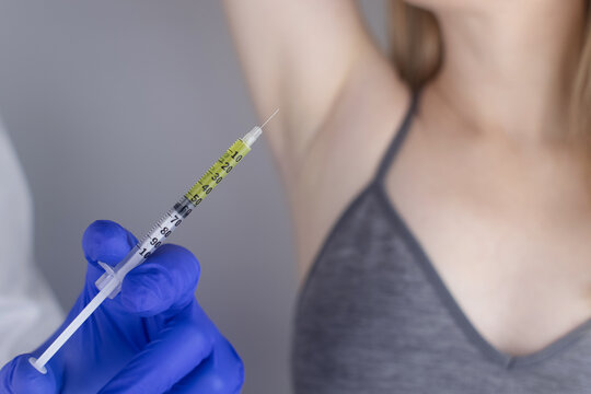 Woman Receiving Botulinum Toxin Injection In Armpit As Treatment Of Hyperhidrosis In Clinic. Treatment Of Problems With Increased Sweating, Anhidrosis, Or Malfunctioning Glands. Cosmetology