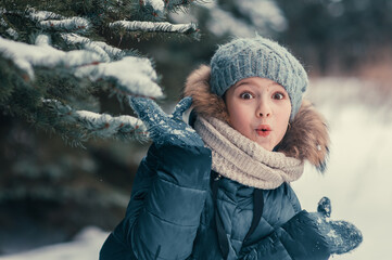 A close-up portrait of a happy girl in a winter fir forest