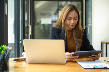 Obraz premium Female assistant or marketing worker working at her desk