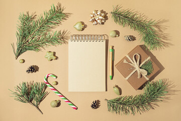 Christmas composition made of craft notebook, pen, present box, fir branches and christmas...
