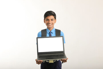 Indian school boy showing laptop screen on white background.