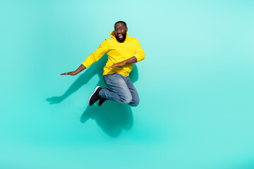 Fototapeta na wymiar Full size photo of excited guy jump dance autumn bargains isolated over cyan color background