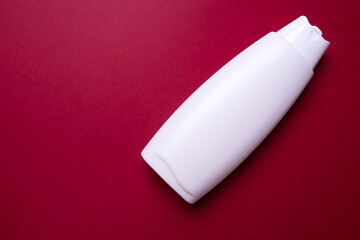bottle of lotion or shampoo on colored background