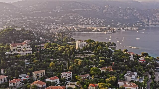 Saint Jean Cap Ferrat France Aerial v13 cinematic establishing shot, drone flyover the luxury neighborhood homes toward plage des fourmis beach with beaulieu-sur-mer in the background - July 2021