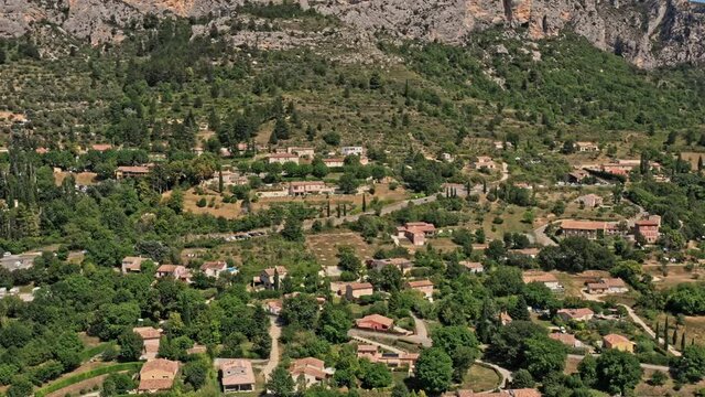 Moustiers Sainte Marie France Aerial v5 panoramic pan shot drone fly around the most beautiful french ancient village and spectacular limestone cliffs - July 2021