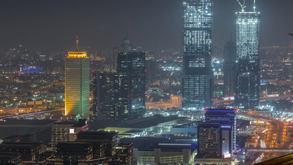 Aerial view of skyscrapers with World Trade center in Dubai night timelapse.