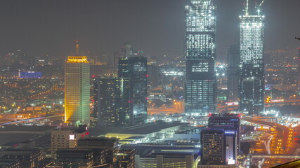 Aerial view of skyscrapers with World Trade center in Dubai all night timelapse.