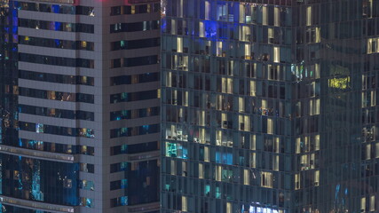 Fototapeta na wymiar Windows in high-rise building exterior in the late evening with interior lights on timelapse