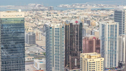 Obraz premium Aerial view of apartment houses and villas behind skyscrapers in Dubai city timelapse, United Arab Emirates