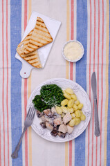 Gnocchi with vegetables and meat in a white sauce.