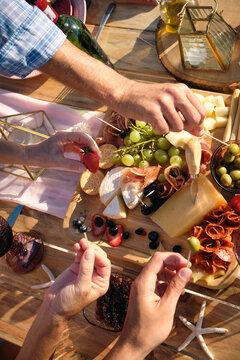 High angle view of friends enjoying meal at dining table during beach picnic, Riviera Nayarit, Mexico