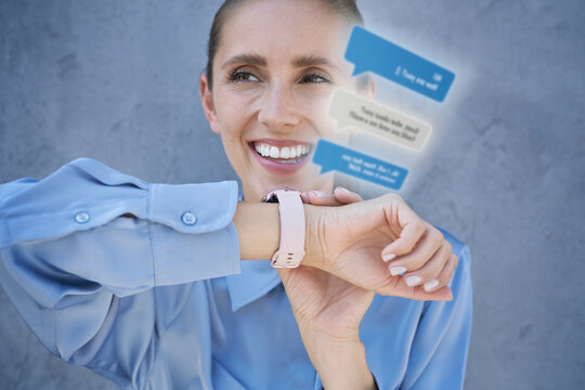 Smiling businesswoman using smart watch in front of blue wall