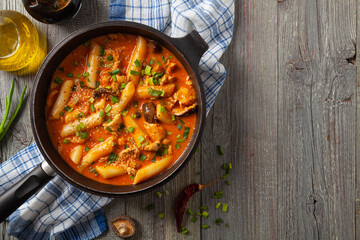 Traditional Korean Tteokbokki rice noodles with chicken, vegetables and shitake mushrooms. Prepared in a pan.