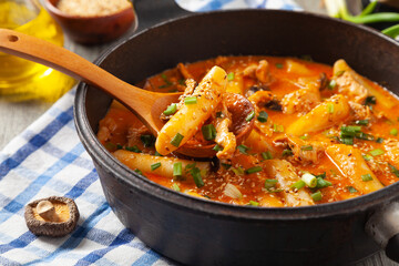 Traditional Korean Tteokbokki rice noodles with chicken, vegetables and shitake mushrooms. Prepared in a pan.