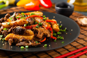Traditional Korean Tteokbokki rice noodles with beef, vegetables and shitake mushrooms. Prepared in a wok.