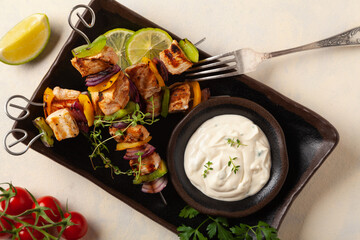 Grilled skewers with chicken, pepper, and onion. Served with sauce. Painted, bright background.