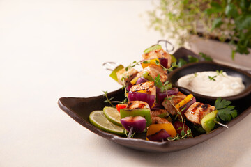 Grilled skewers with chicken, pepper, and onion. Served with sauce. Painted, bright background.