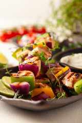 Grilled skewers with chicken, pepper, and onion. Served with sauce. Painted, bright background.