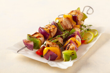 Grilled skewers with chicken, pepper, and onion. Served with sauce. Served on paper try.